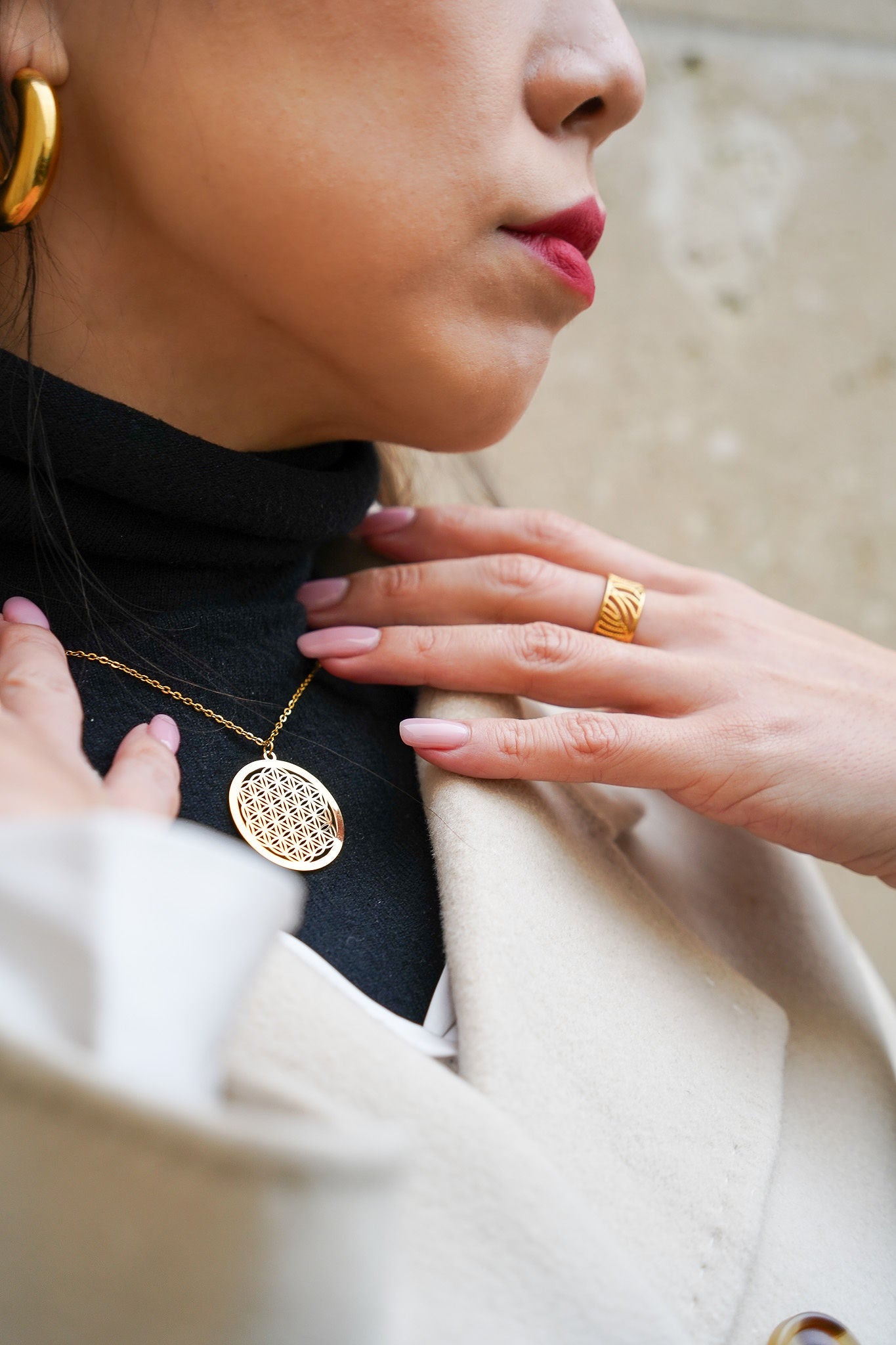 Collier Fleur de Vie doré de Eight Ounce Jewelry – porté sur un col roulé noir, bijou spirituel et intemporel