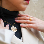 Collier Fleur de Vie doré de Eight Ounce Jewelry – porté sur un col roulé noir, bijou spirituel et intemporel